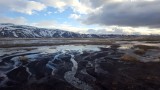Melting snows beneath the mighty live volcano Hekla (beneath the clouds)