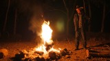 Bob beside his campfire burning a hollow log that acts like a chimney